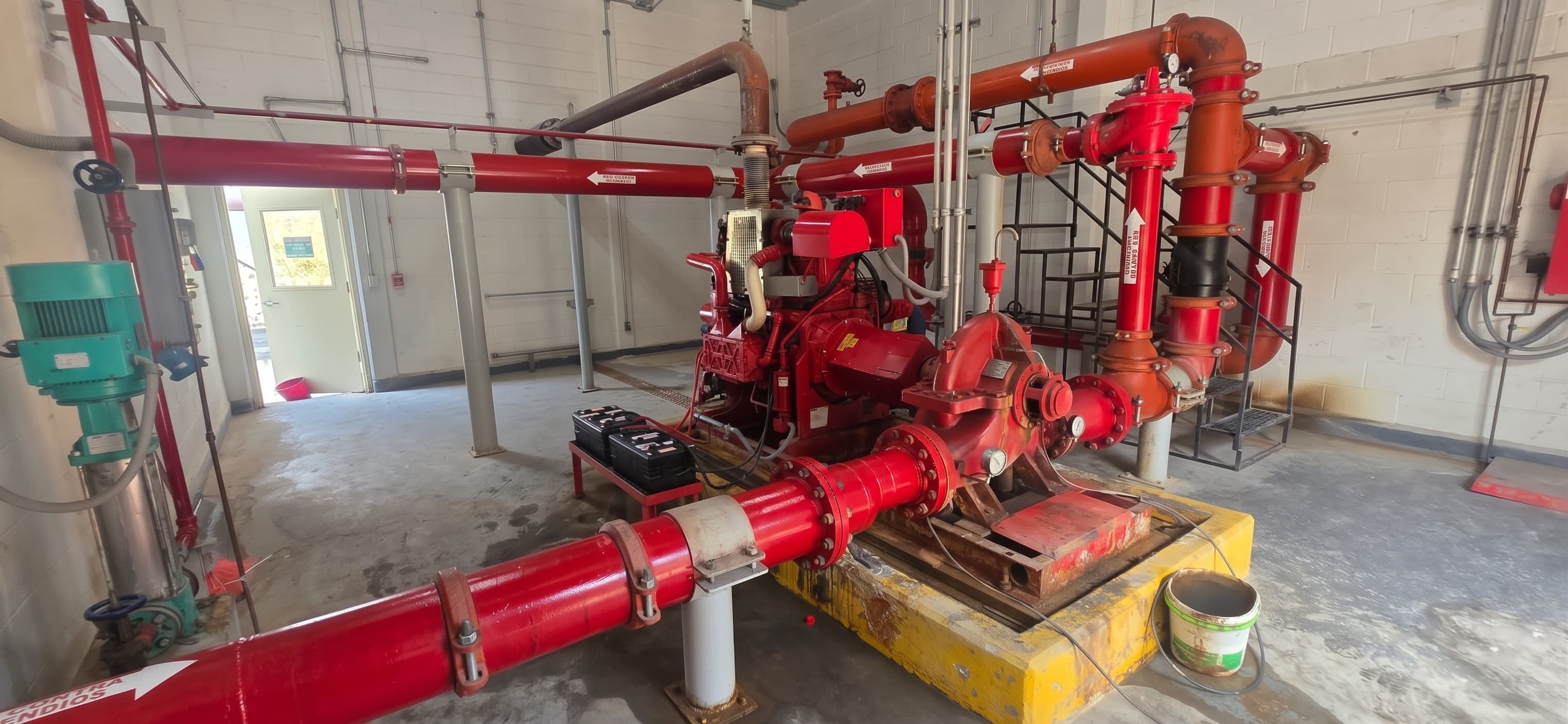 Cuarto de bombas contra incendio con motor diésel, bomba y tubería roja.